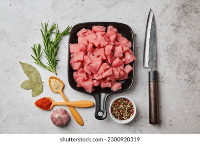 Top view of raw pork goulash in ceramic pan