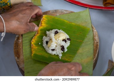Top view of Raw steamed sticky rice with banana and vigna mungo on a banana leaf or Thai people call Khao Tom Mud which is being prepared to wrap and steam.