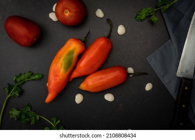 A Top View Of Red Chili Peppers On A Black Messy Kitchen Table