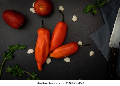 A Top View Of Red Chili Peppers On A Black Messy Kitchen Table