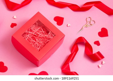 Top View Of Red Empty Gift Box On Pink Color Table. Valentines Day Packing. Decor Ribbons And Hearts.