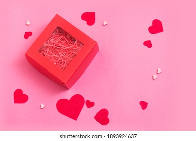 Top View Of Red Empty Gift Box On Pink Color Table. Valentines Day Packing. Decor Hearts.