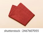 top view with red empty kitchen napkin isolated on table background. Folded cloth for mockup with copy space, Flat lay. Minimal style.