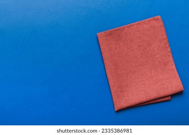 top view with red empty kitchen napkin isolated on table background. Folded cloth for mockup with copy space, Flat lay. Minimal style.