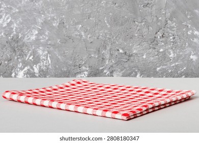 top view with red empty kitchen napkin isolated on table background. Folded cloth for mockup with copy space, Flat lay. Minimal style.