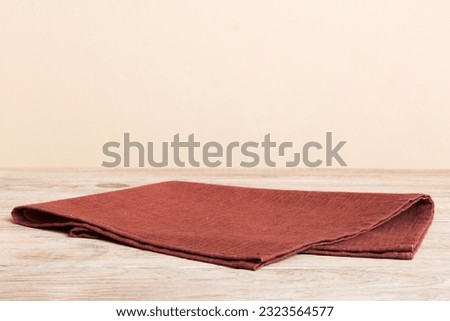 top view with red empty kitchen napkin isolated on table background. Folded cloth for mockup with copy space, Flat lay. Minimal style.