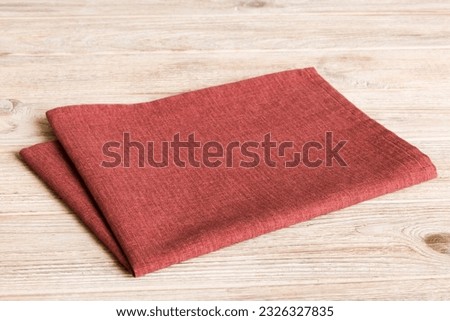 top view with red empty kitchen napkin isolated on table background. Folded cloth for mockup with copy space, Flat lay. Minimal style.