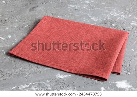 top view with red empty kitchen napkin isolated on table background. Folded cloth for mockup with copy space, Flat lay. Minimal style.