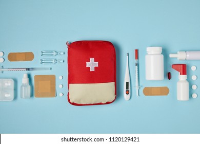 top view red first aid kit bag blue surface and medical supplies