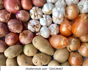 Top View Of Red Onions, Holland Onions, Garlic And Potatoes In Supermarket.