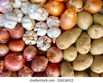 Top View Of Red Onions, Holland Onions, Garlic And Potatoes In Supermarket.