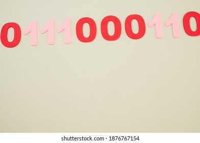 A top view of red and pink binary codes on a white surface