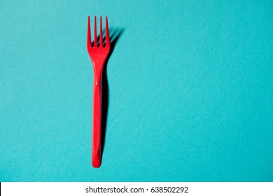 Top View Of Red Plastic Fork Isolated On Blue