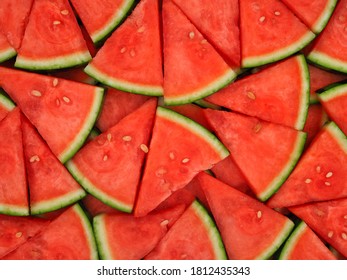 Top view of red seedless watermelon cut into small pieces with shell are arranged for food background.