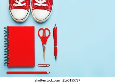 Top view of red sneakers and red school supplies with space for tex on blue background. Back to school concept - Powered by Shutterstock