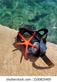 A Top View Of A Red Starfish On Swimming Goggles Near The Pool