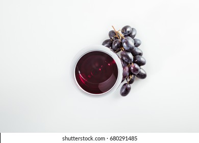 Top View Of Red Wine In Grass And Ripe Grapes Isolated On White