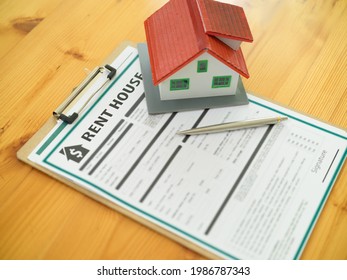 Top View Of Rent House Agreement, Pen And House Model On Wooden Table, Real Estate Concept