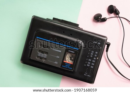 Top view of retro walkman on pink and green background