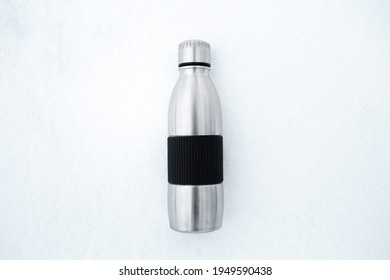 Top View Of Reusable Steel Thermo Water Bottle On Snow.