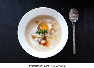 Top View Of Rice Porridge With Pork And Egg Or Congee Is Similar To Boil Rice But It Has Softer Texture Is On The Black Table For Breakfast In The Moring