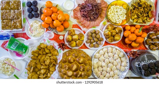 Top view of rich table spread with many different dishes, fruits and deserts.