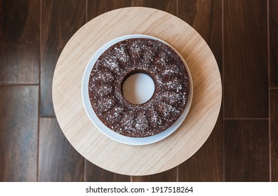 top view of a ring chocolate sponge cake with a wood background
