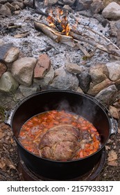 Top View Of Roast Meat In An Iron Cast Pot As Dutch Oven Cooking Concept.