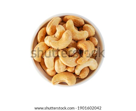 Top view of Roasted Cashew nuts in white cup isolated on white background with clipping path