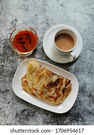 Top View Of Roti Canai, Teh Tarik And Curry.