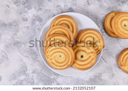 Top view of round ring shaped spritz biscuits, a type of German butter cookies made by extruding dough with a press fitted with patterned holes
