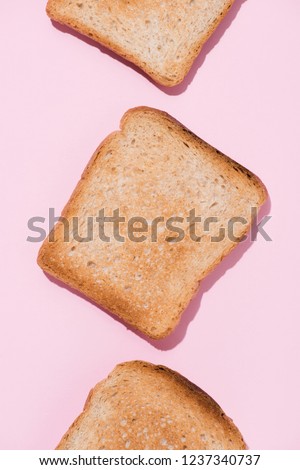 top view of row of delicious toasts on pink tabletop
