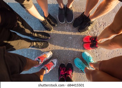 Top view of runners standing in a huddle with their feet together - Powered by Shutterstock