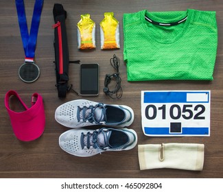 Top View Running Shoes, Marathon Race Bib (number), Medal, Runners Gear And Energy Gels On Wood Background, Sport, Fitness And Healthy Lifestyle Concept.