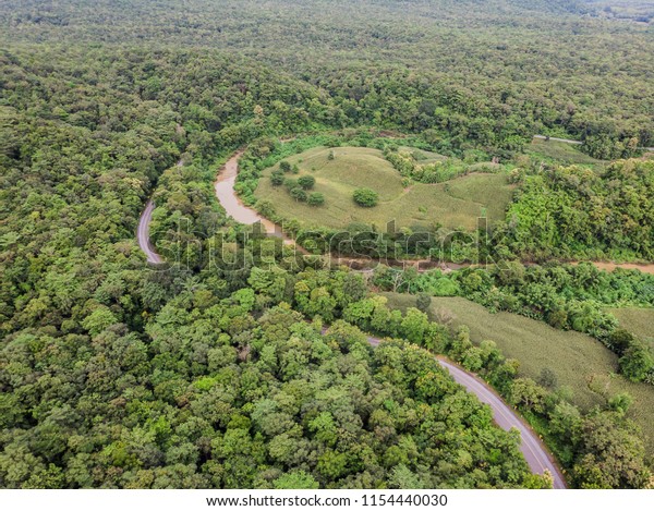 Top View\
of Rural Road, Path through the green forest and countryside of\
Thailand, Top view aerial photo from\
drone.