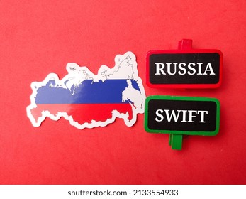 Top view Russia flag and wooden board with text RUSSIA SWIFT on red background.