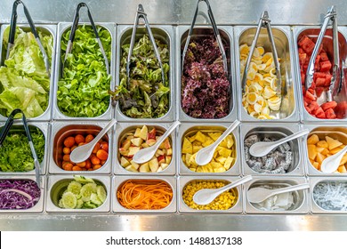 Top View Of Salad Bar With Various Types Of Vegetables And Fruits Including Lettuce, Tomato, Corn, Egg, Watermelon, Carrot, Cucumber, And More