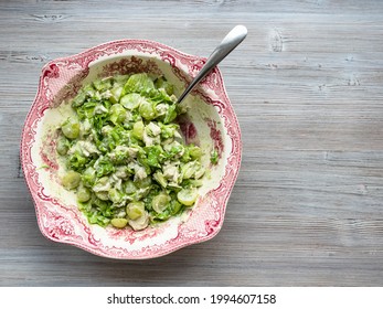 Top View Of Salad With Grapes, Tarragon And Chicken In Ornamental Bowl With Spoon On Gray Wooden Table