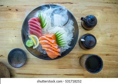Top View Salmon Sashimi And Tuna Sashimi On Ice With Dry Ice Smoke, Japanese Food