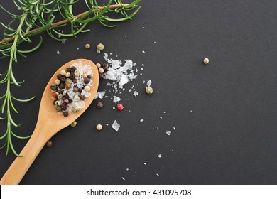 Top View Salt And Pepper On Wooden Spoon With Rosemary