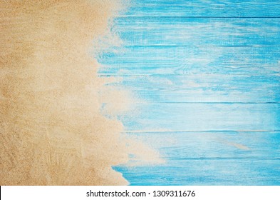 Top View Of Sandy Beach And Marine Blue Planks Pier. Background With Copy Space And Visible Sand And Wood Texture.