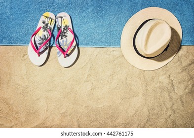 Top view of sandy beach with summer accessories and copy space around products. Blank mock up for advertising or packaging.