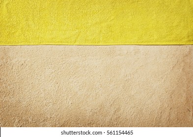 Top View Of Sandy Beach With Towel Frame. Background With Copy Space And Visible Sand Texture. Top Border Made Of Towel