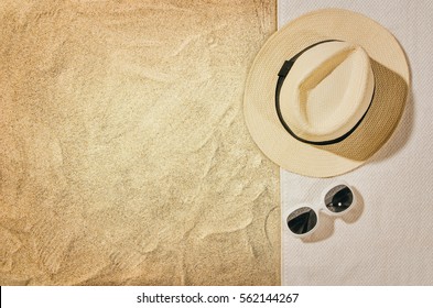 Top view of sandy beach with towel frame and summer accessories. Background with copy space and visible sand texture. Right border made of towel