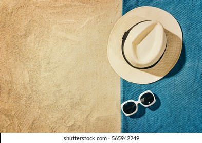 Top View Of Sandy Beach With Towel Frame And Summer Accessories. Background With Copy Space And Visible Sand Texture. Right Border Made Of Towel