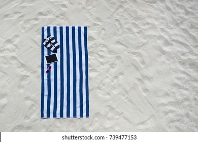 Top View Of Sandy Beach With Towel Frame And Summer Accessories. Background With Copy Space And Visible Sand Texture.