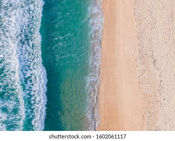 Top view of sandy beach with turquoise blue water, summer seascape with foam, beautiful waves, aerial drone shot. - Powered by Shutterstock