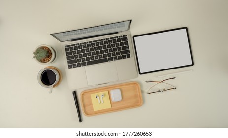 Top View Of Scene Creator With Laptop, Mock Up Tablet, Stationery, Glasses, Earphone And Decoration On White Desk 