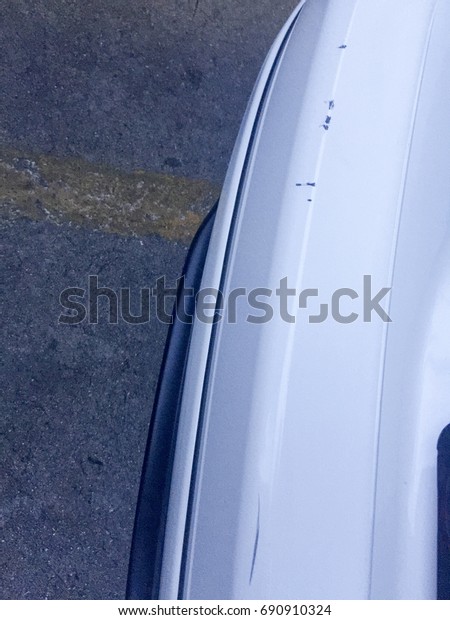 Top view of scratch at the Rear bumper from car crash\
on white color car