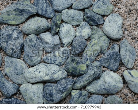 A top view of sea blue stones on a colorful sand background. Decoration for house. Texture, decoration concept.